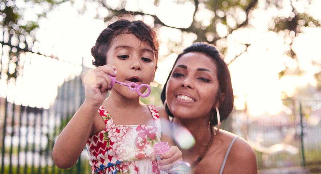 Mom blowing bubbles with daughter