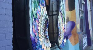 Close-up of stained glass angel wings in jewel tones