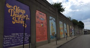 Panels of 21 murals with the first reading, Keep Dayton Funky in yellow letters on purple backdrop